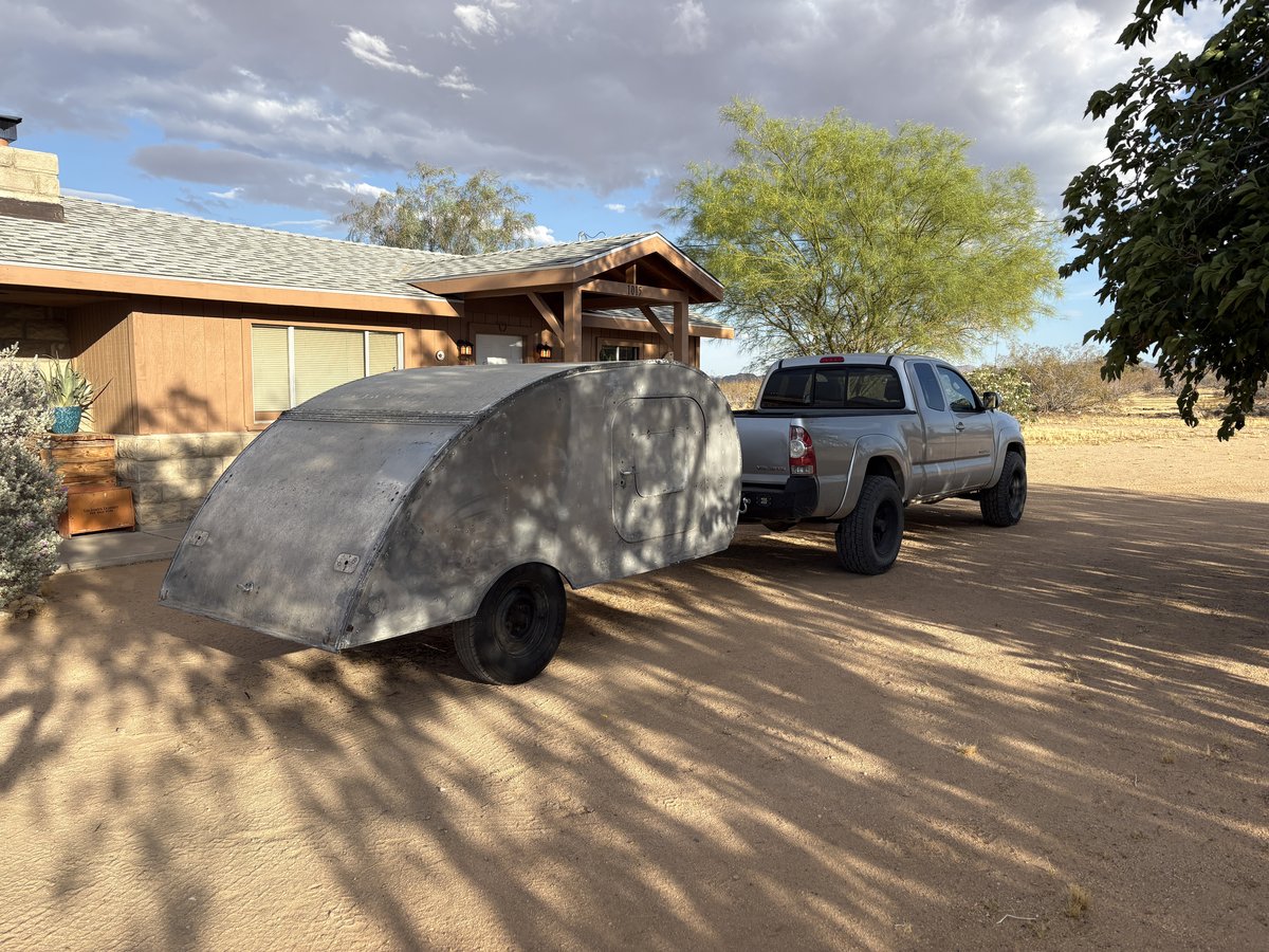 1948 Tourette Teardrop Trailer parked outside a desert home